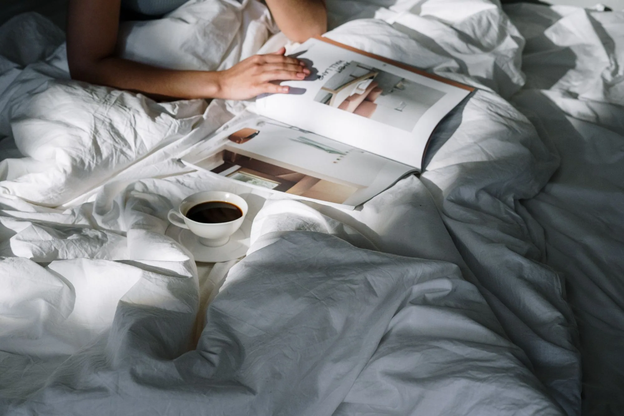 Relaxing morning in bed with a cup of coffee and a magazine to read. Editorial photograph for our gel mask guide for Dubai shoppers.