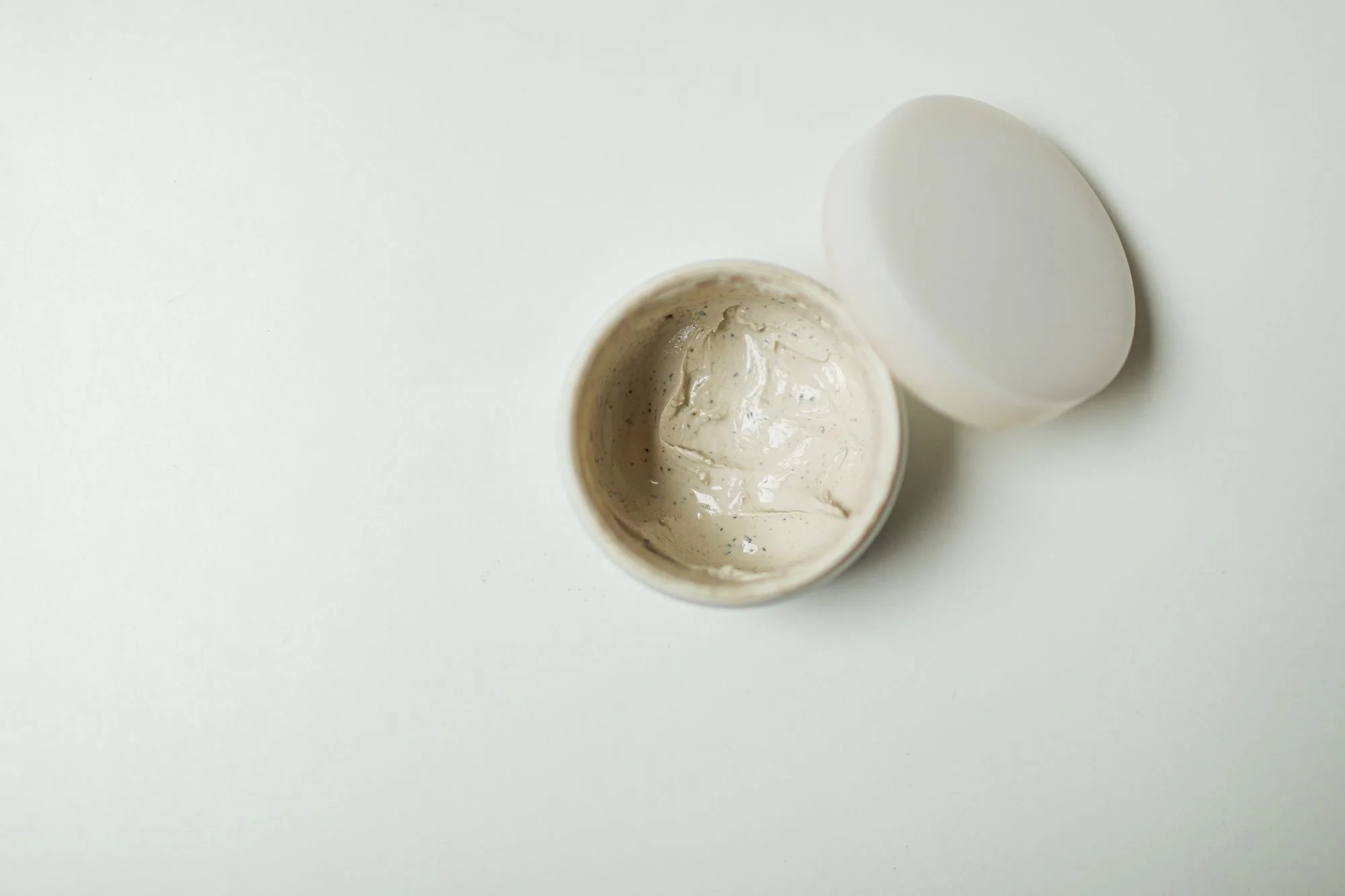 Close-up of an opened cream jar, ideal for skincare product representation.