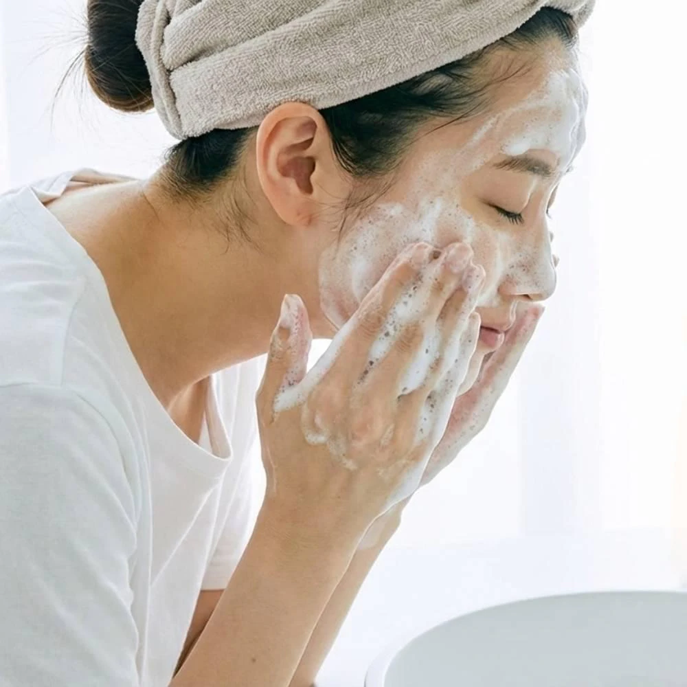 A model washing her face with AGTHEORY Clear Wash Foam